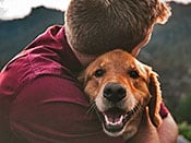 man hugging dog